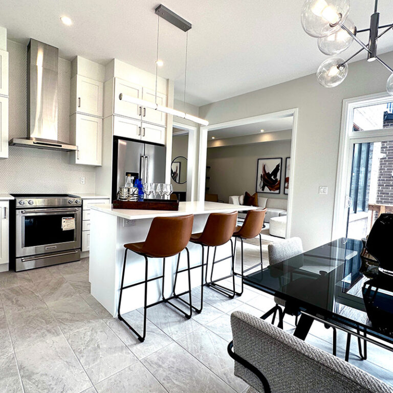 Contemporary white eat-in kitchen with island and stainless steel appliances.